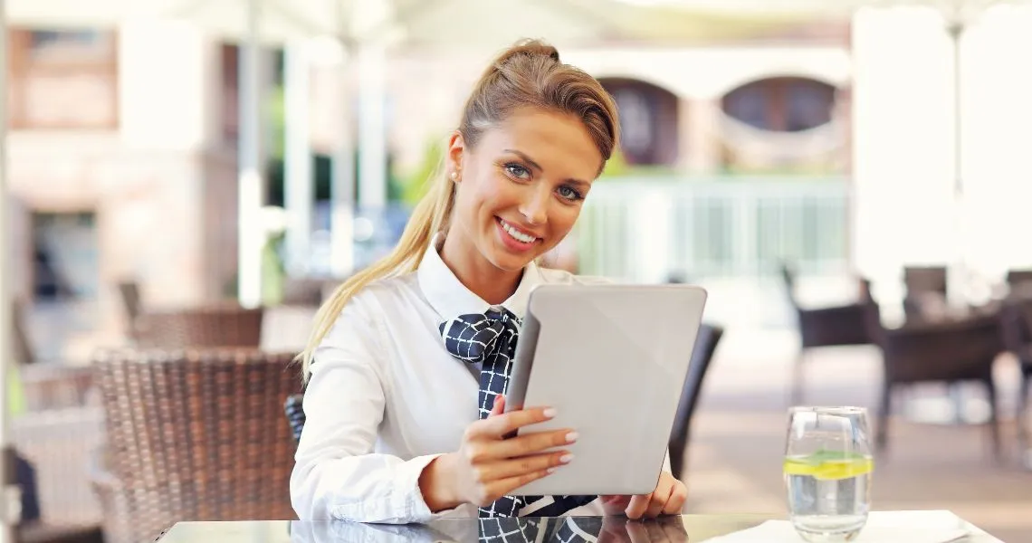 Responsable hôtel ou restaurant gérant sa visibilité Google sur tablette — stratégie SEO sans budget pub